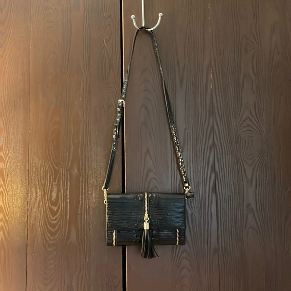 No brand black faux leather purse with black tassel and zippers for design.